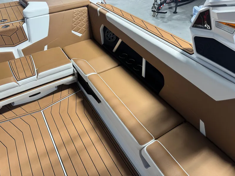 Slide: The Image of 2025 Nautique Super Air Nautique GS24 interior with tan and white seating. - 10