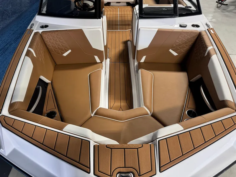 Slide: The Image of 2025 Nautique Super Air Nautique GS24 boat interior with tan and white seating. - 15