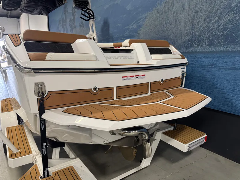 Slide: The Image of 2025 Nautique Super Air Nautique GS24 boat, rear view, in showroom setting. - 4