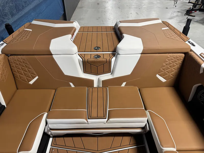 Slide: The Image of 2025 Nautique Super Air Nautique GS24 interior with tan and white upholstery, diamond stitching. - 6