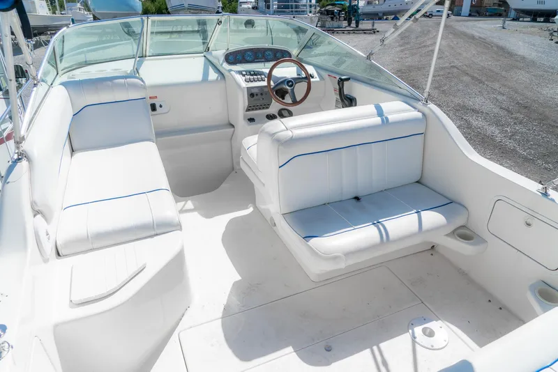 Slide: The Image of 1995 Sea Ray 250 Sundancer boat interior with white seating and steering wheel. - 10