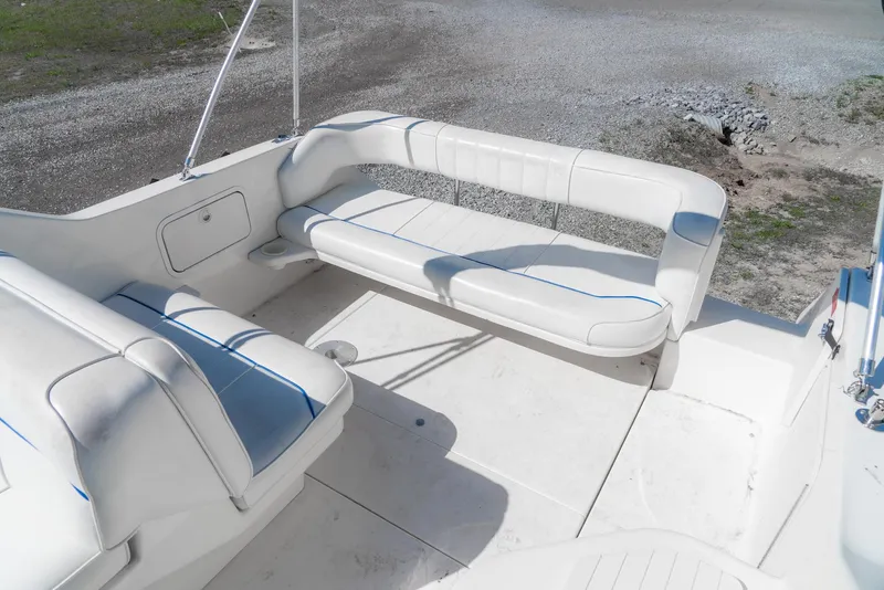 Slide: The Image of 1995 Sea Ray 250 Sundancer boat interior with white seating and blue accents. - 11
