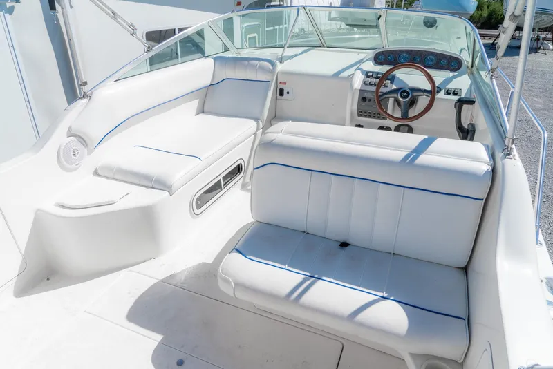 Slide: The Image of 1995 Sea Ray 250 Sundancer boat interior with white seating and steering wheel. - 12
