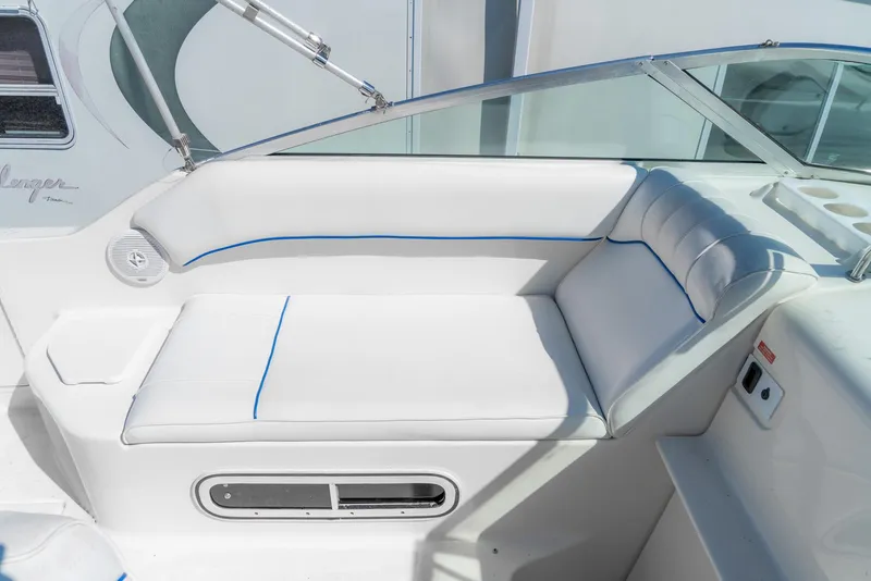 Slide: The Image of 1995 Sea Ray 250 Sundancer boat interior with white cushioned seating and blue accents. - 13