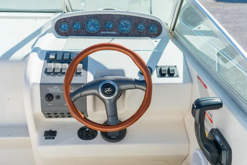 Slide: The Image of 1995 Sea Ray 250 Sundancer helm with wooden steering wheel and instrument panel. - 16
