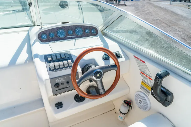 Slide: The Image of 1995 Sea Ray 250 Sundancer helm with wooden steering wheel and control panel. - 17
