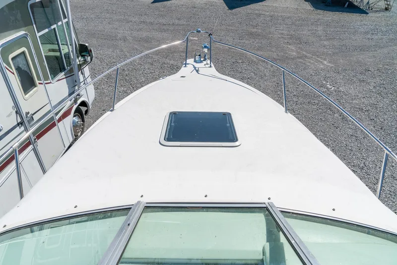 Slide: The Image of 1995 Sea Ray 250 Sundancer boat deck with hatch, parked on gravel. - 18