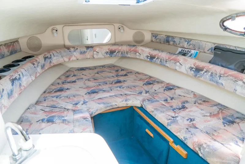 Slide: The Image of 1995 Sea Ray 250 Sundancer cabin interior with patterned upholstery and compact design. - 20