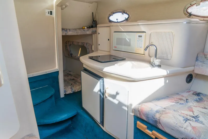 Slide: The Image of Interior of 1995 Sea Ray 250 Sundancer boat with kitchenette and seating area. - 21