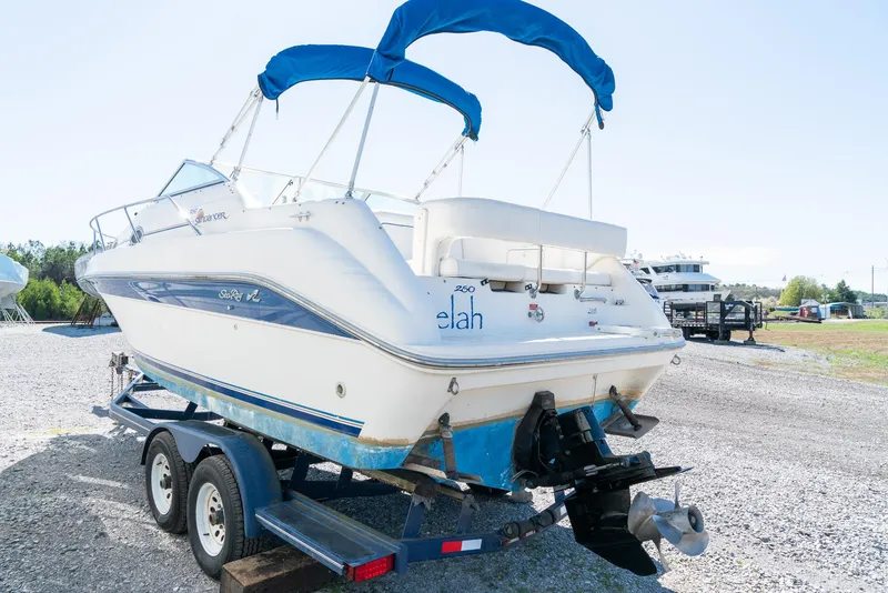 Slide: The Image of 1995 Sea Ray 250 Sundancer boat on trailer with blue canopy, parked outdoors. - 7