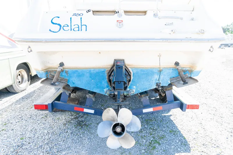 Slide: The Image of 1995 Sea Ray 250 Sundancer boat on trailer, rear view with visible propeller. - 8