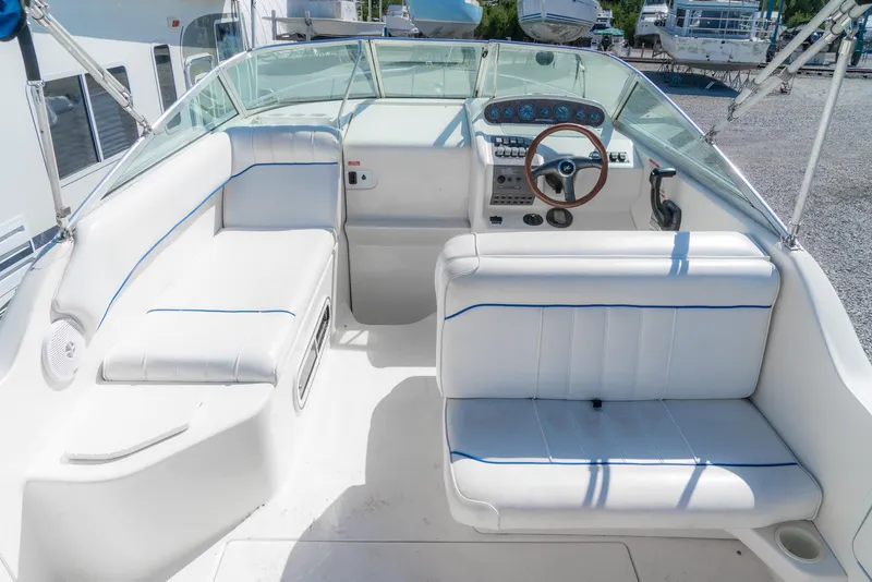 Slide: The Image of 1995 Sea Ray 250 Sundancer boat interior with white seating and steering wheel. - 9
