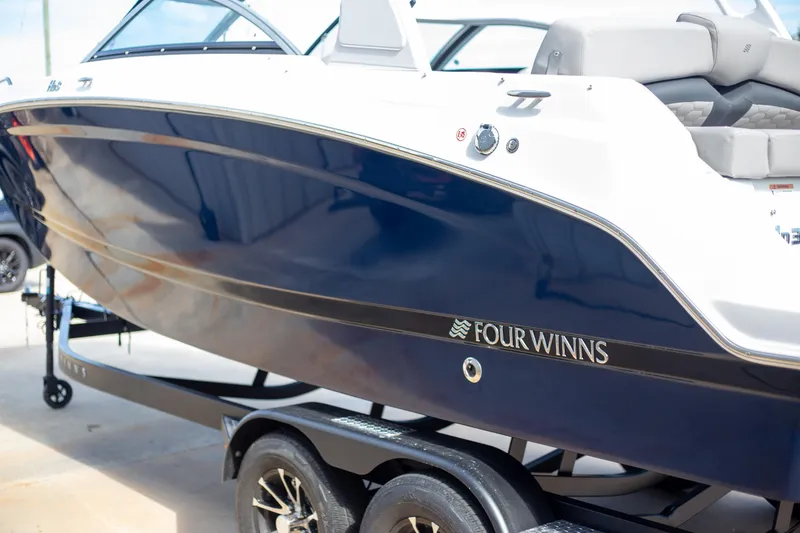 Slide: The Image of 2025 Four Winns HD3 boat on trailer, sleek blue and white design. - 3