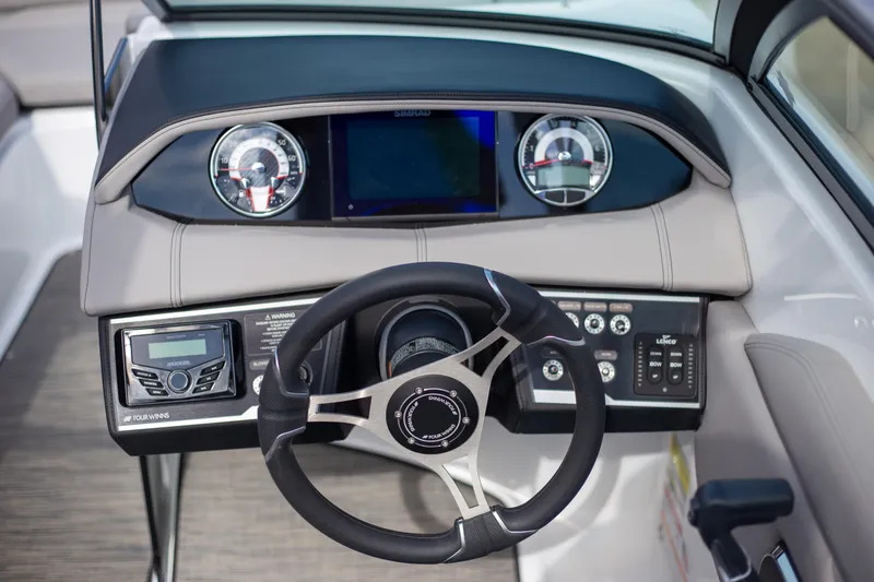 Slide: The Image of 2025 Four Winns HD3 boat dashboard with modern controls and steering wheel. - 6