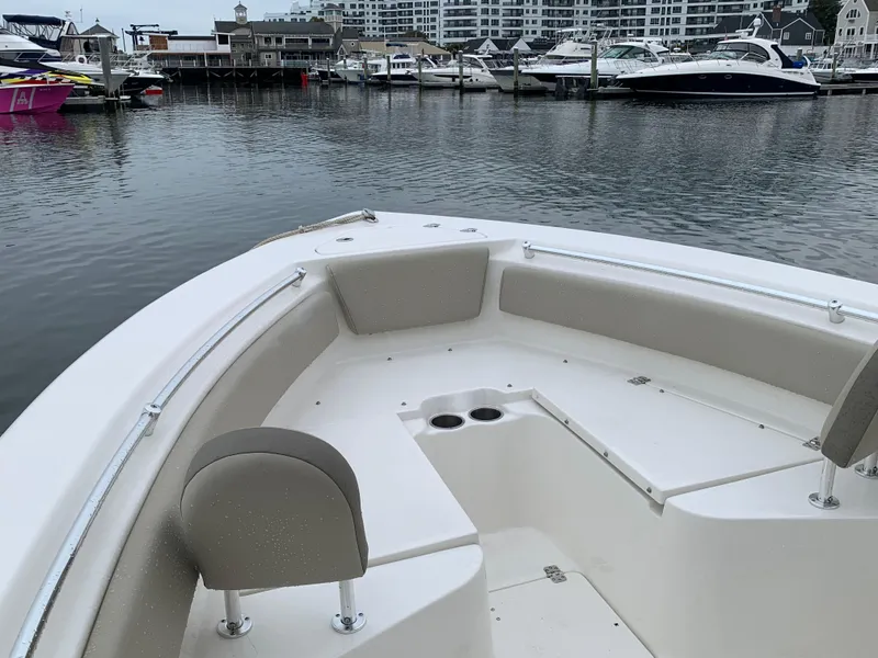 Slide: The Image of 2023 Key West 239 FS boat interior at marina, featuring spacious seating and cup holders. - 2