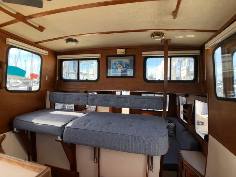 Slide: The Image of Interior of 1989 Nordic Tug 32 with cushioned seating and wooden accents. - 13