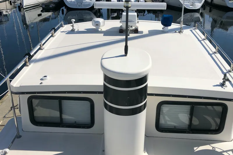 Slide: The Image of 1989 Nordic Tug 32 boat deck with windows and railing in marina. - 6