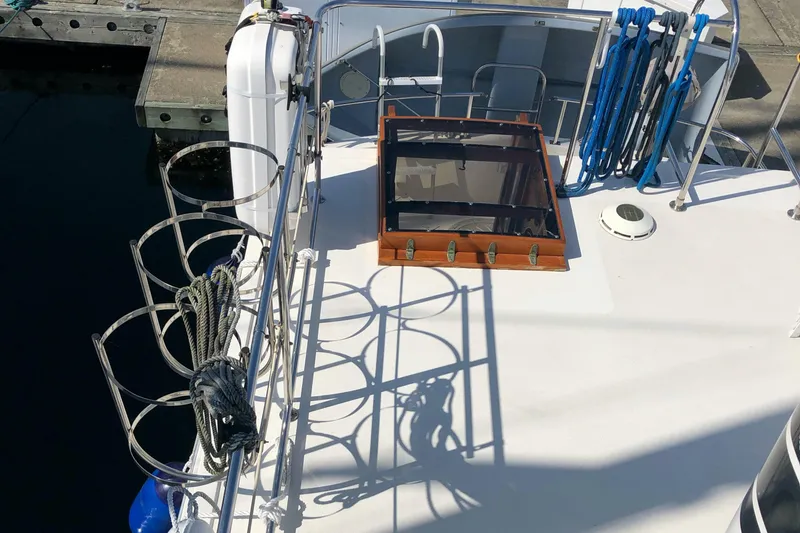 Slide: The Image of 1989 Nordic Tug 32 deck with hatch, ropes, and dockside view. - 8