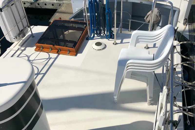 Slide: The Image of Nordic Tug 32 (1989) deck with stacked white chairs and nautical equipment. - 9