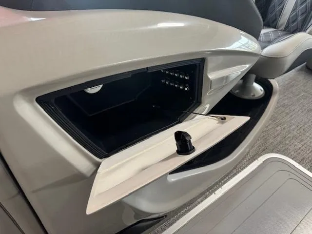 Slide: The Image of Interior storage compartment of 2025 Barletta Lusso 23UC boat, open with visible controls. - 16