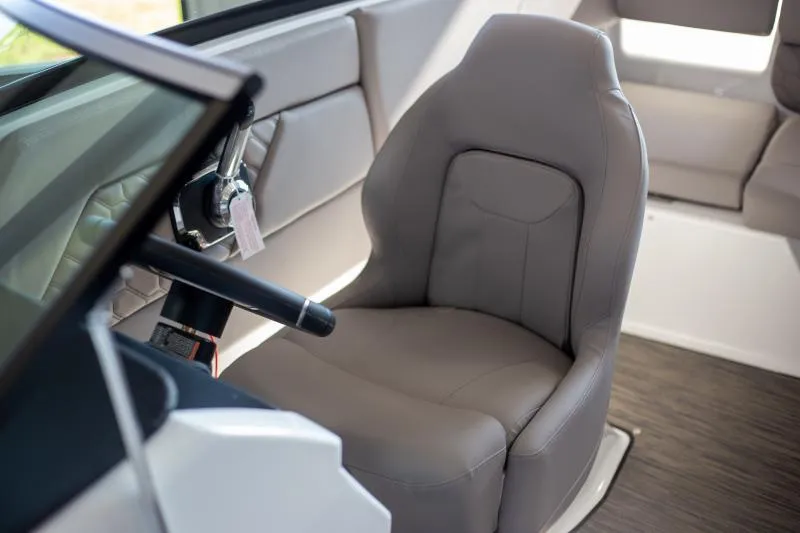 Slide: The Image of 2025 Four Winns H1 boat interior with gray captain's seat and steering wheel. - 7