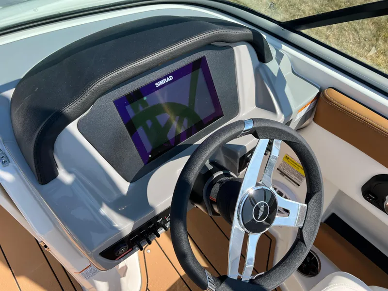 Slide: The Image of 2025 Chaparral 21 SSi boat dashboard with Simrad display and steering wheel. - 17