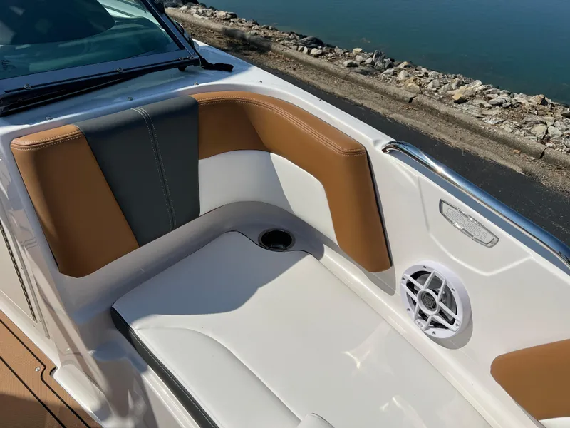 Slide: The Image of 2025 Chaparral 21 SSi boat interior with tan and gray seating, speaker, and cup holder. - 21