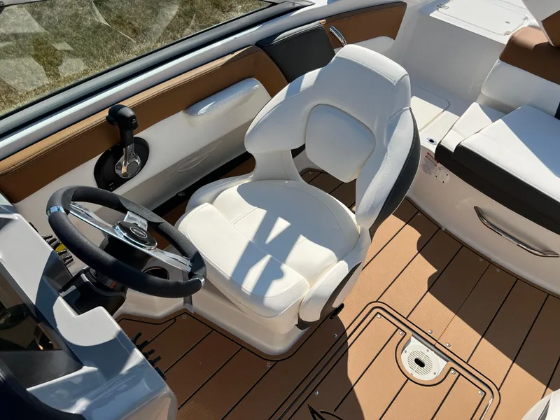 Slide: The Image of 2025 Chaparral 21 SSi boat interior with white captain's chair and sleek steering wheel. - 24