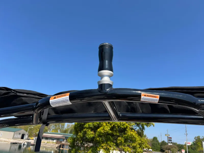 Slide: The Image of 2025 Chaparral 21 SSi boat canopy with warning labels under clear blue sky. - 27