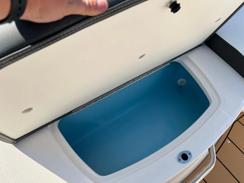 Slide: The Image of 2025 Chaparral 21 SSi boat storage compartment open, showing interior. - 29