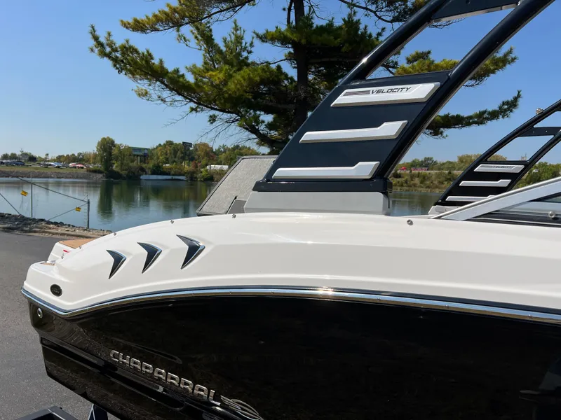 Slide: The Image of 2025 Chaparral 21 SSi boat by a serene lake, showcasing sleek design and modern features. - 33