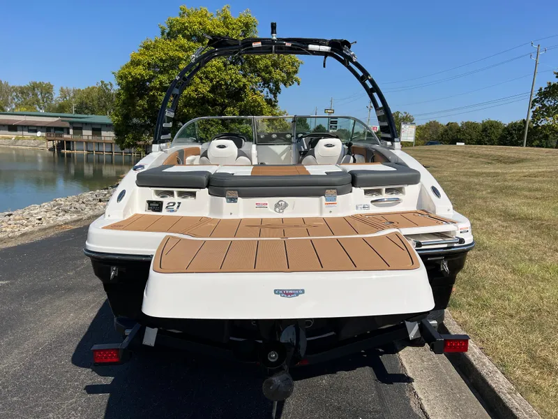 Slide: The Image of 2025 Chaparral 21 SSi boat, rear view, parked near a lake on a sunny day. - 5