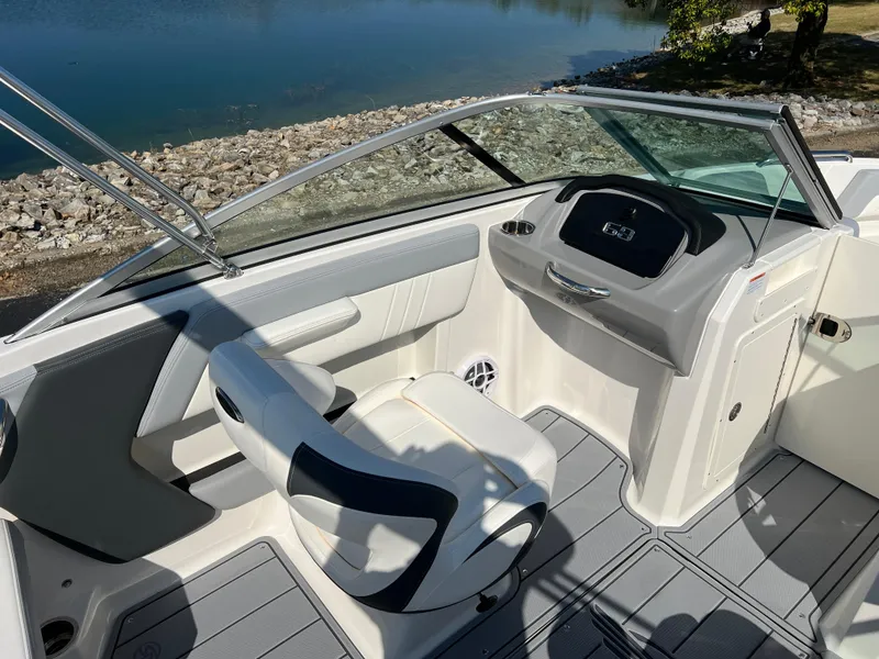 Slide: The Image of 2025 Chaparral 21 SSi boat interior with sleek seating and modern dashboard by the water. - 11