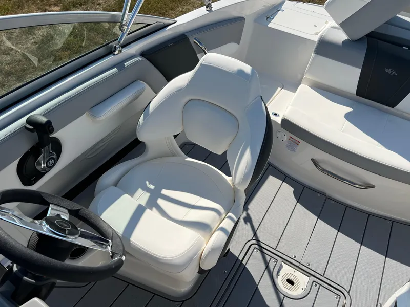 Slide: The Image of 2025 Chaparral 21 SSi boat interior with white seating and steering wheel. - 18