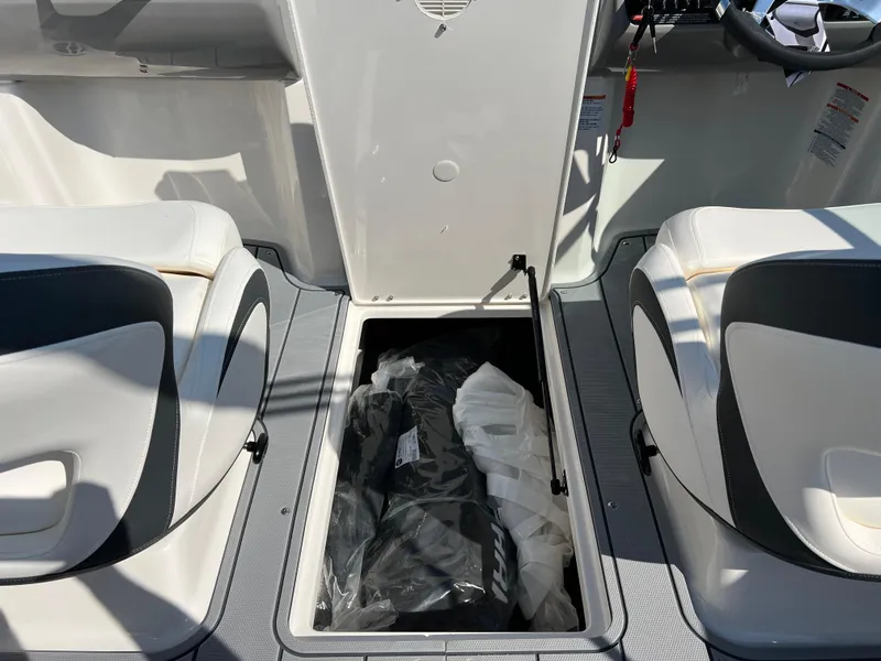 Slide: The Image of 2025 Chaparral 21 SSi boat interior storage compartment between seats. - 23