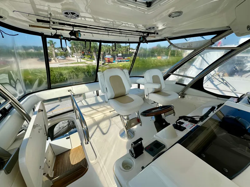Slide: The Image of 2008 Sea Ray 58 Sedan Bridge helm with Garmin navigation, overlooking serene waters. - 18