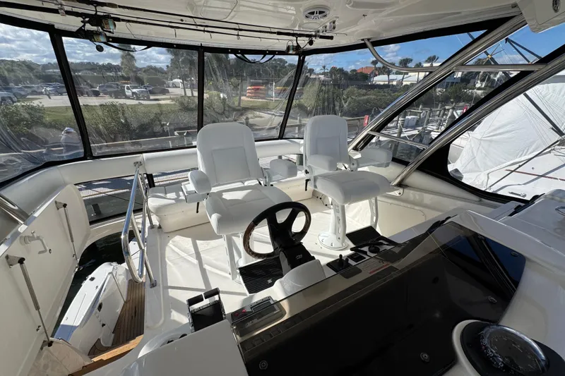Slide: The Image of 2008 Sea Ray 58 Sedan Bridge helm with white seating and panoramic windows. - 22