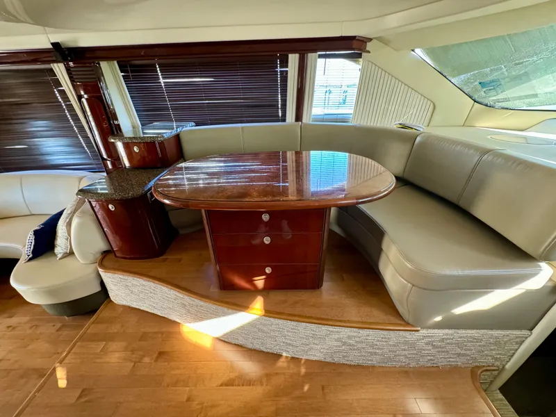 Slide: The Image of 2008 Sea Ray 58 Sedan Bridge yacht with white seating and wooden deck. - 8