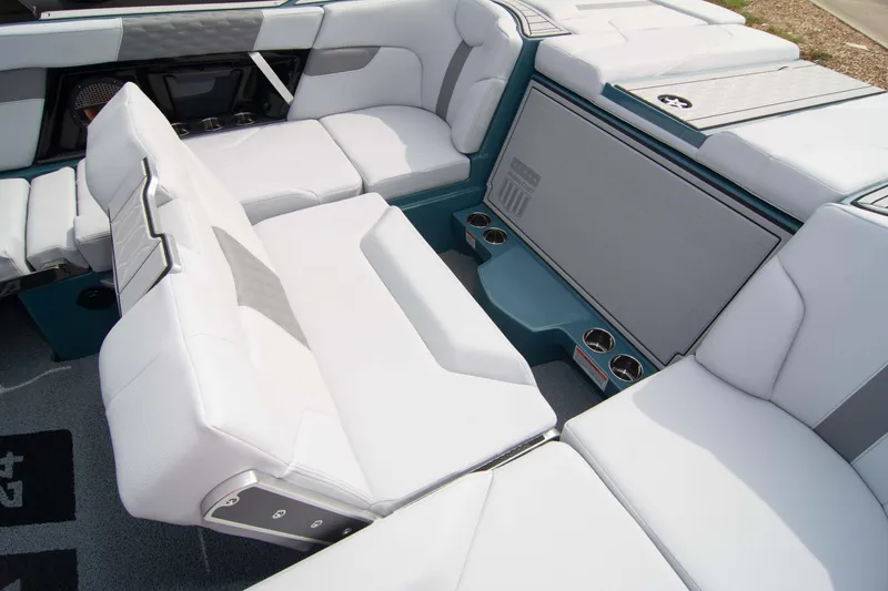 Slide: The Image of 2025 MasterCraft XT24 boat interior with white seating and cup holders. - 39
