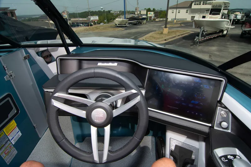 Slide: The Image of 2025 MasterCraft XT24 boat dashboard with steering wheel and digital display. - 47