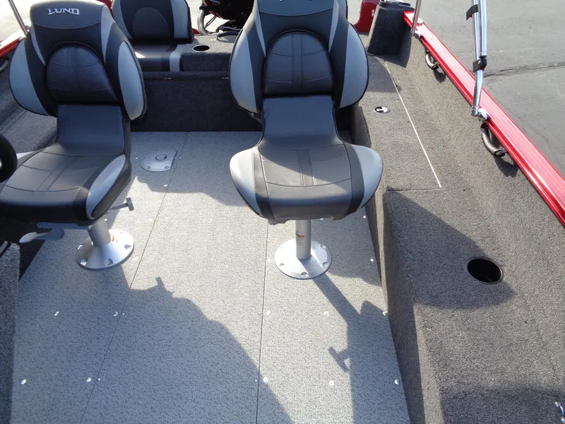 Slide: The Image of 2025 Lund 1650 Rebel XL SS boat interior with gray seating and carpeted flooring. - 15