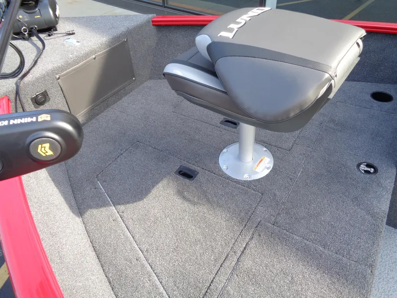 Slide: The Image of 2025 Lund 1650 Rebel XL SS boat interior with gray seating and carpeted flooring. - 16