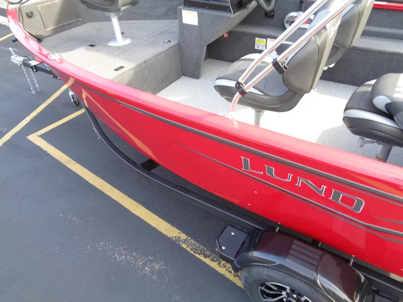Slide: The Image of Red 2025 Lund 1650 Rebel XL SS boat with seating, parked on asphalt. - 4