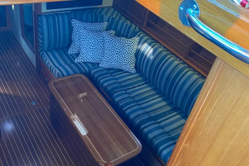 Slide: The Image of Interior of 2001 Grand Banks 49 Eastbay SX with striped seating and wooden table. - 16