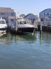 Slide: The Image of 2001 Grand Banks 49 Eastbay SX docked in a marina with waterfront homes. - 2