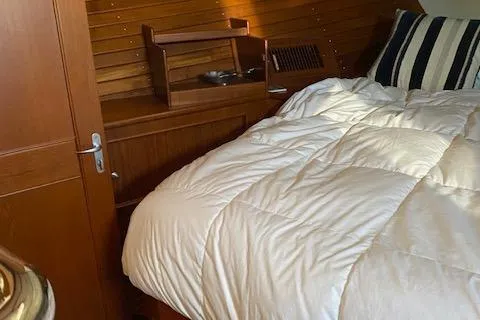 Slide: The Image of Cozy cabin interior of 2001 Grand Banks 49 Eastbay SX with wooden paneling and bedding. - 23