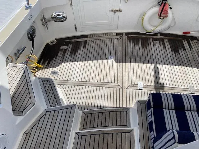Slide: The Image of 2001 Grand Banks 49 Eastbay SX yacht deck with striped seating and wooden flooring. - 27