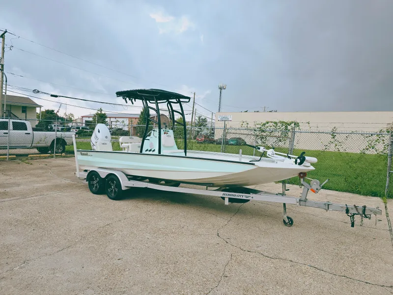 Slide: The Image of 2021 Excel Bay Pro boat on trailer in parking lot, overcast sky. - 1