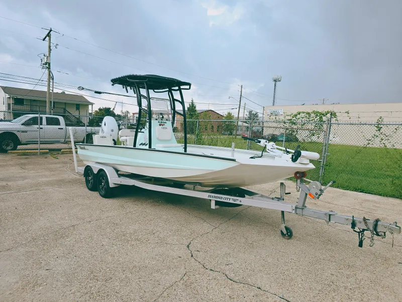 Slide: The Image of 2021 Excel Bay Pro boat on trailer in parking lot. - 2