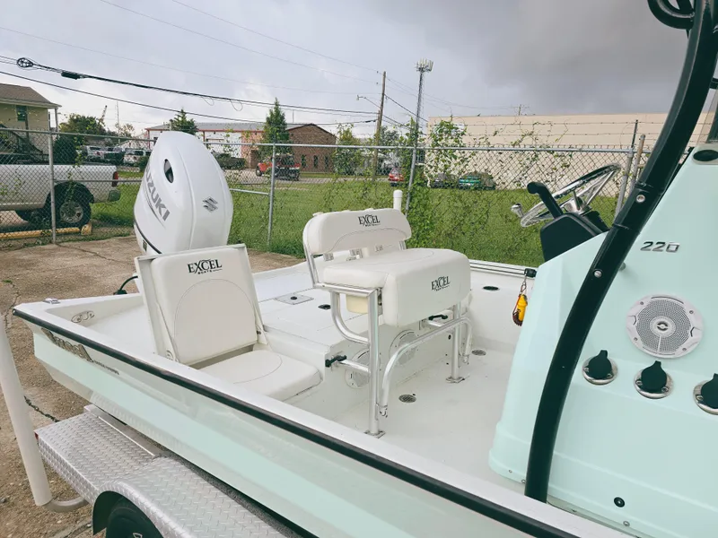Slide: The Image of 2021 Excel Bay Pro boat with seating and controls, parked outdoors. - 6